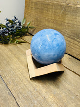 Load image into Gallery viewer, Natural Blue Calcite sphere on wooden stand