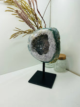 Load image into Gallery viewer, Large Natural Agate Geode with Quartz crystals inside on black stand