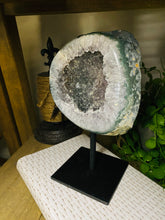 Load image into Gallery viewer, Large Natural Agate Geode with Quartz crystals inside on black stand
