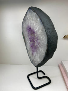 Amethyst Crystal geode slice on black display stand