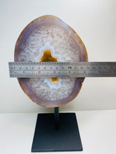 Load image into Gallery viewer, Large Natural Agate Geode with Quartz crystals inside on black stand