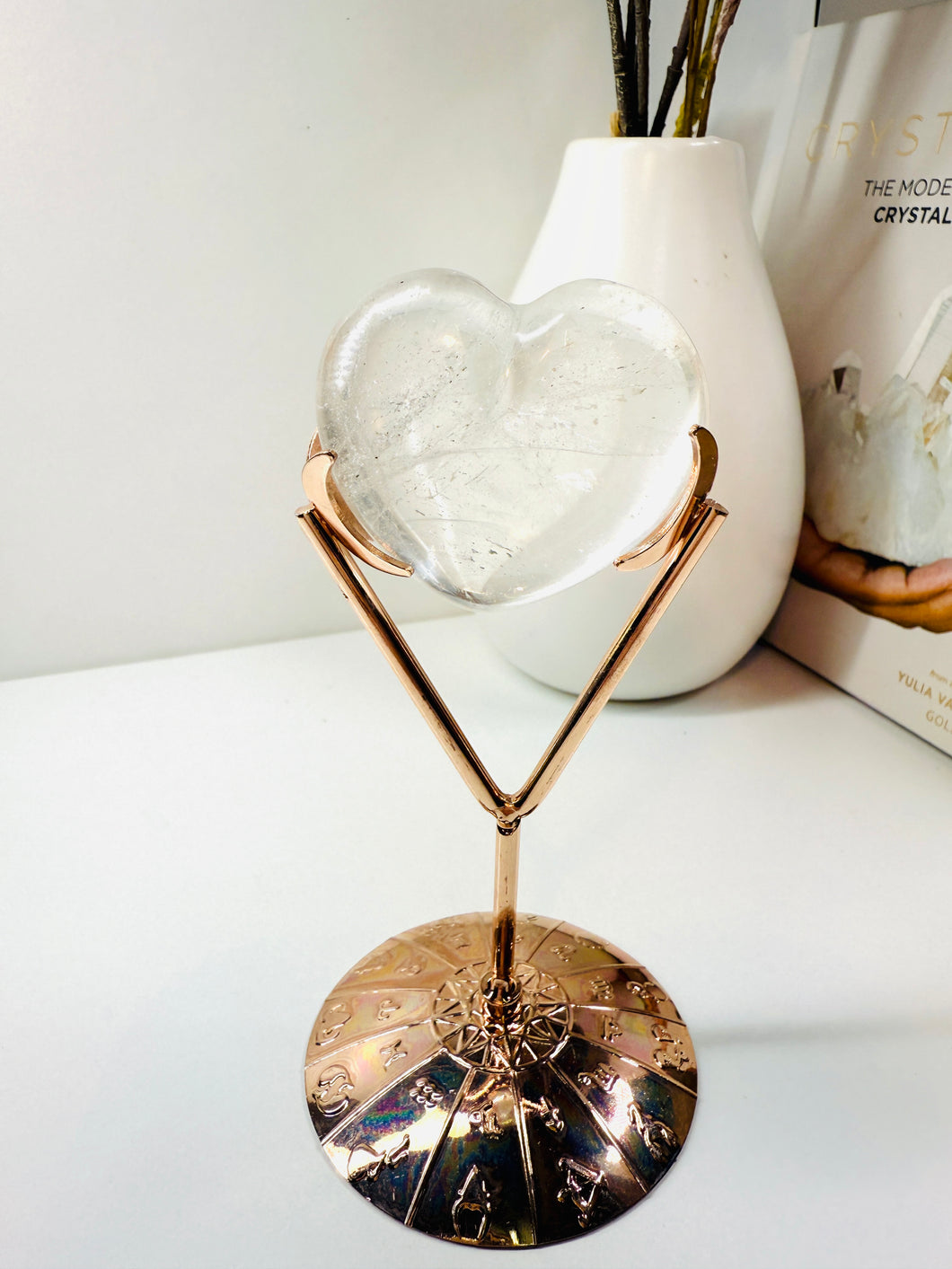 Polished Clear Quartz love heart on rose colored metal stand with zodiac sign