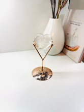 Load image into Gallery viewer, Polished Clear Quartz love heart on rose colored metal stand with zodiac sign