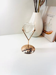 Polished Clear Quartz love heart on rose colored metal stand with zodiac sign