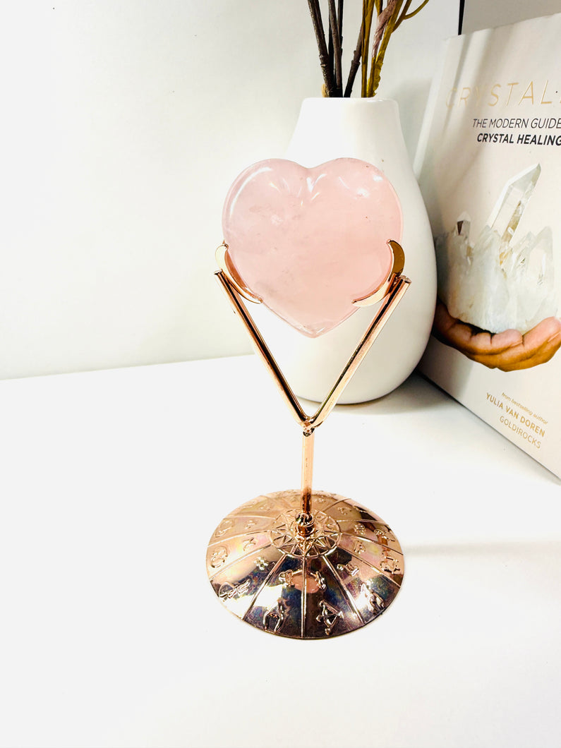 Polished Rose Quartz love heart on rose colored metal stand with zodiac sign