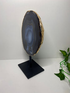 Natural polished Agate slice on black stand with gold electroplating around the edges 09
